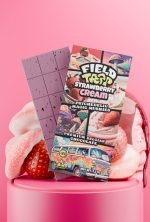 Field Trip Strawberry Cream magic mushroom chocolate bar with opened squares and strawberries in background