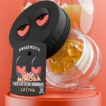 Jar of Rose Mimosa Concentrate THCA Live Resin Diamonds Sativa 2g with mimosa cocktails in background