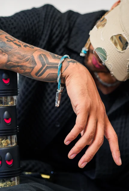 Person holding cannabis container outdoors.
